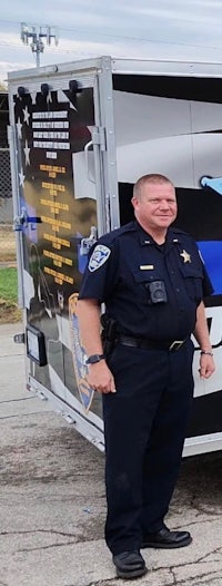 a police officer standing in front of a trailer