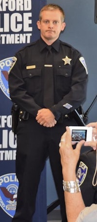a police officer takes a picture with a cell phone