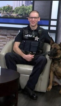 a police officer sits in a chair with a dog