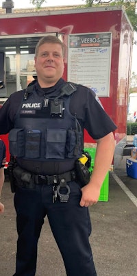 two police officers standing in front of a food truck